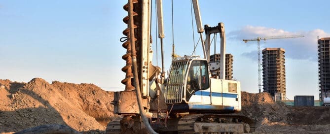Urban construction site with dynamic compaction equipment working on stabilizing heterogeneous fill materials for future development.