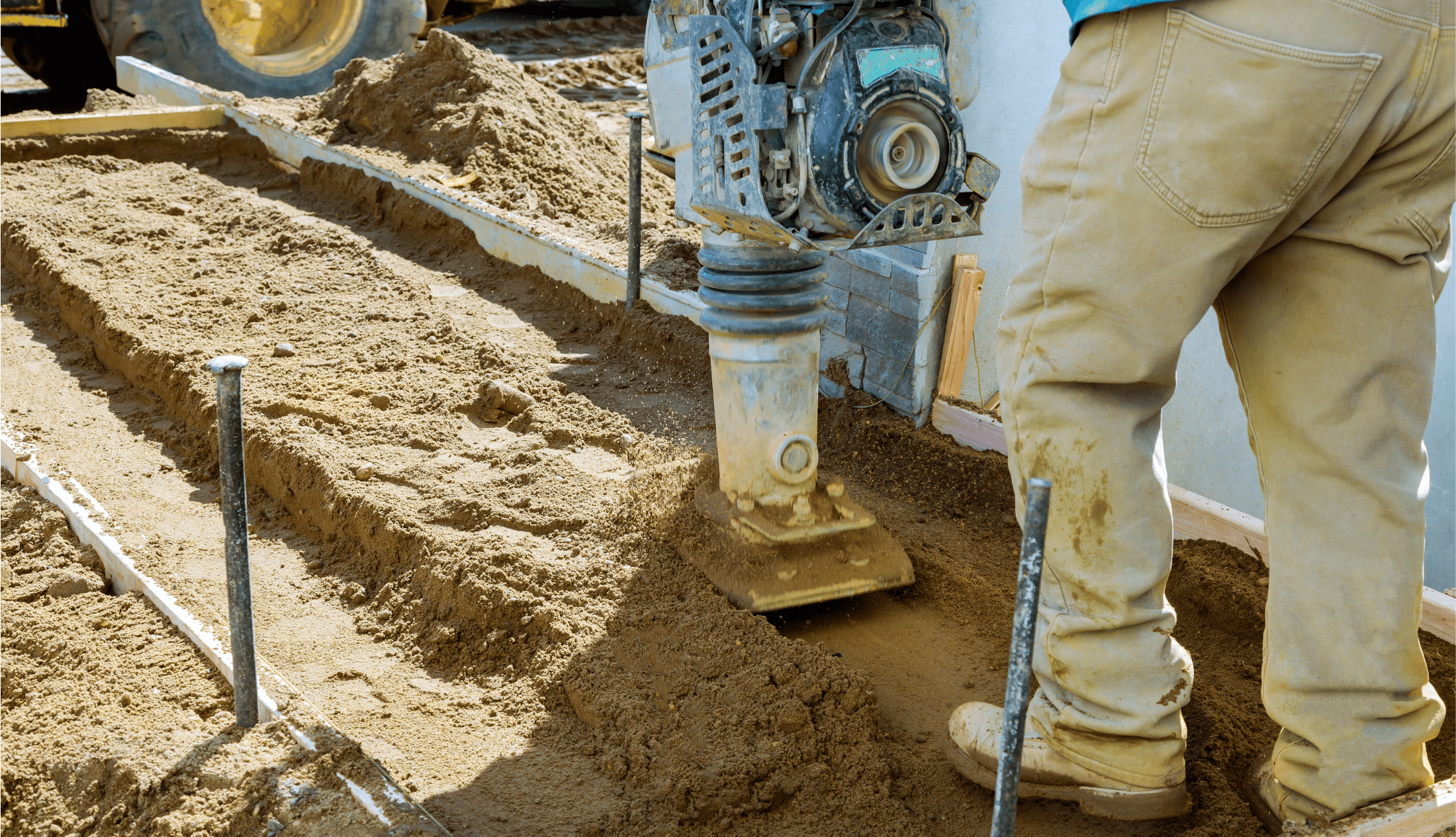 A man using vibration monitoring, a technique that plays a pivotal role in ensuring the success of ground compaction efforts.