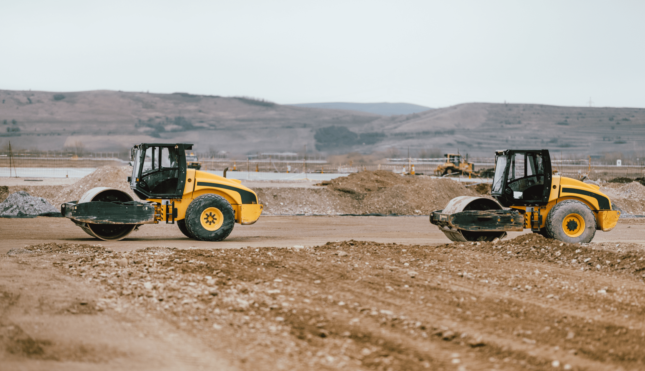 Two Vibratory Soil Compactors during road and highway construction.