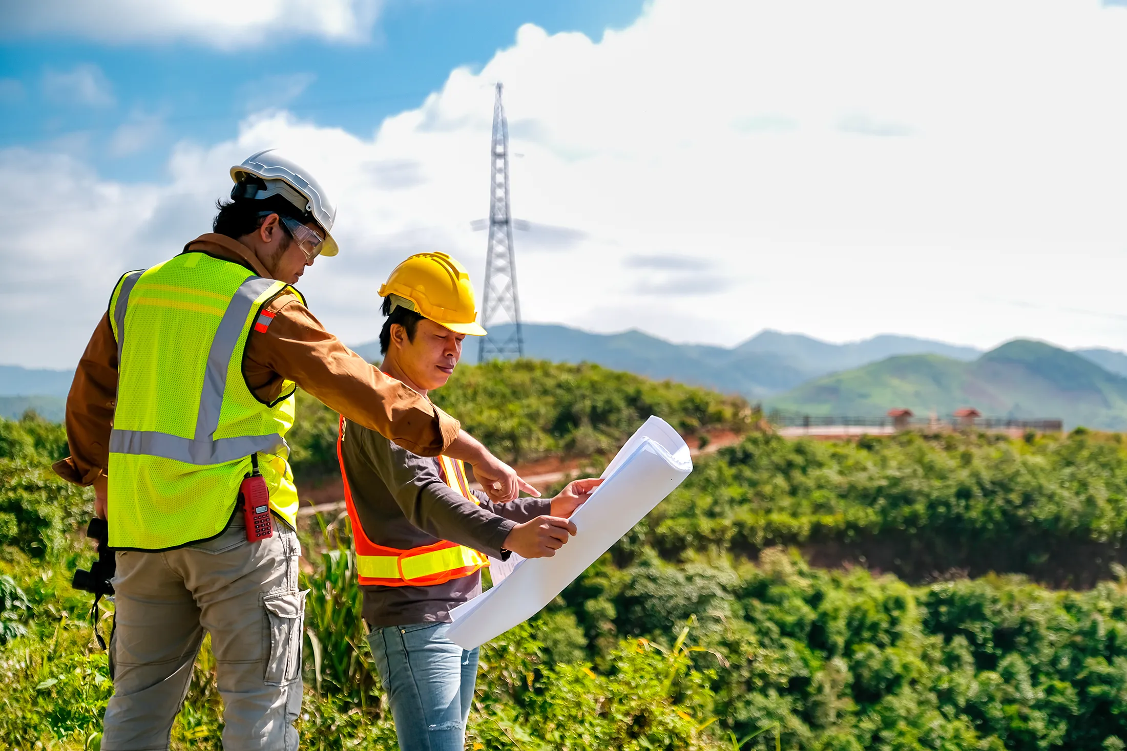 engineer-head-point-to-the-planer-paper-and-discus-2025-03-09-14-48-50-utc Engineer head point to the planer paper and discuss with his team for the construction near the forest with copy space in image.
