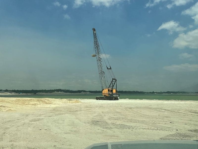 POWGbm8A Heavy construction crane positioned on a cleared site near water, illustrating ground improvement methods used to achieve solid ground and increase bearing capacity.