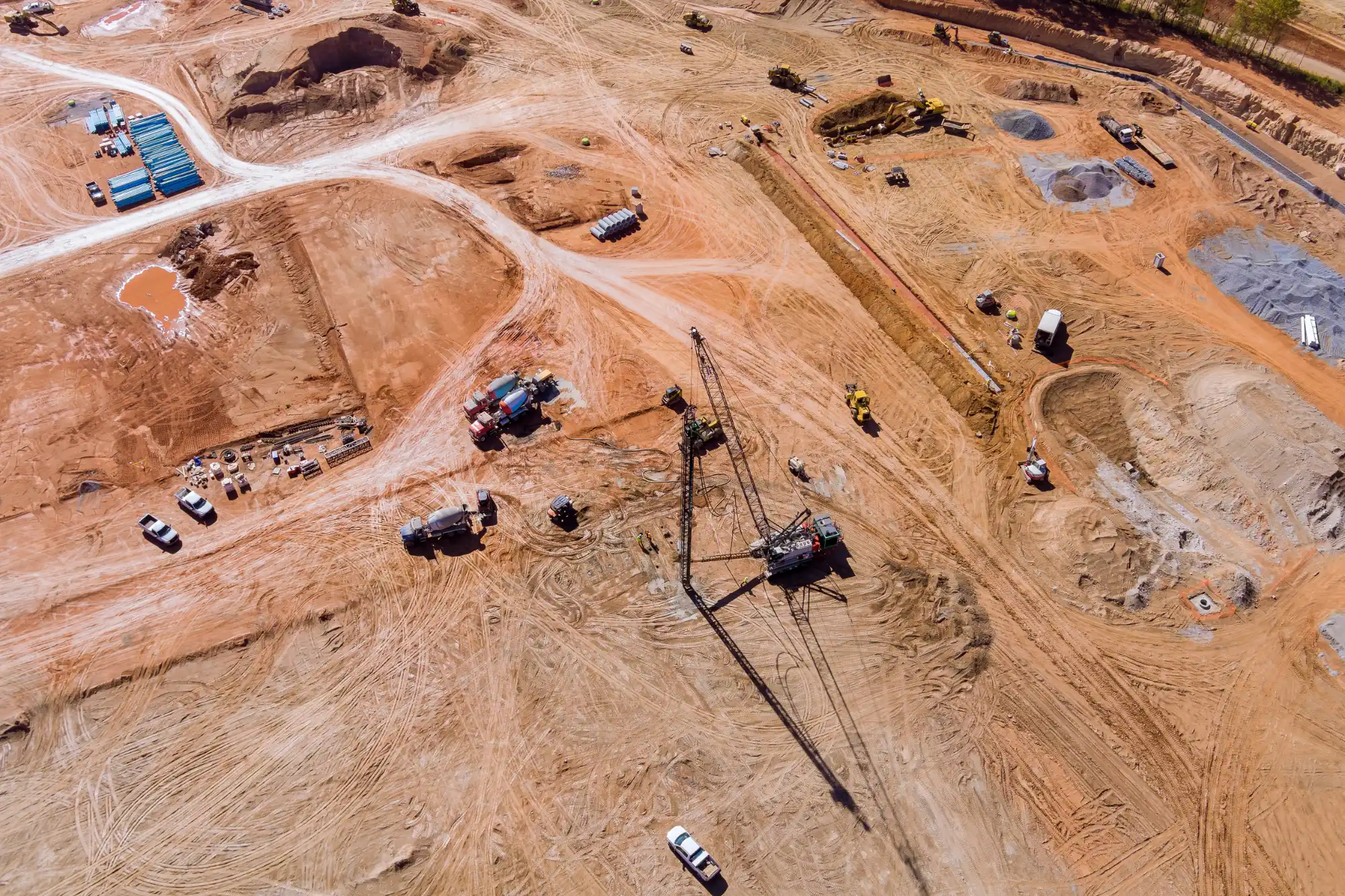 aerial-view-active-construction-site-crane-heavy-equipment-densification Ground vibration monitoring sensors and data acquisition equipment measuring subsurface movement.